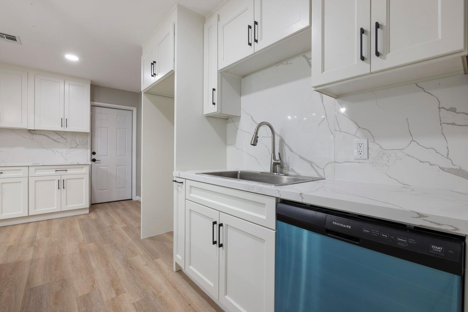 a kitchen with a sink stainless steel appliances and cabinets
