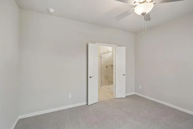 an empty room with closet and a chandelier fan