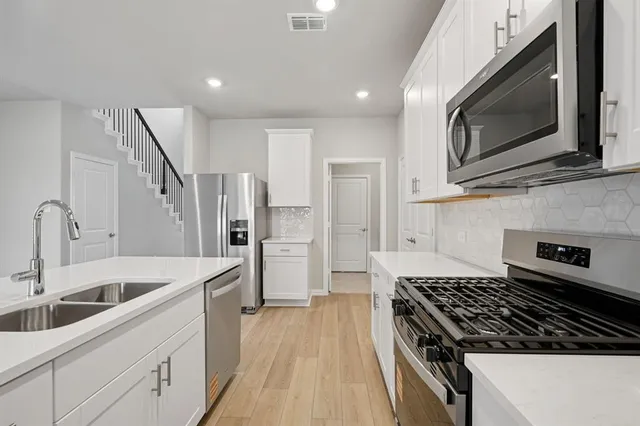 a kitchen with a sink a stove a microwave and cabinets