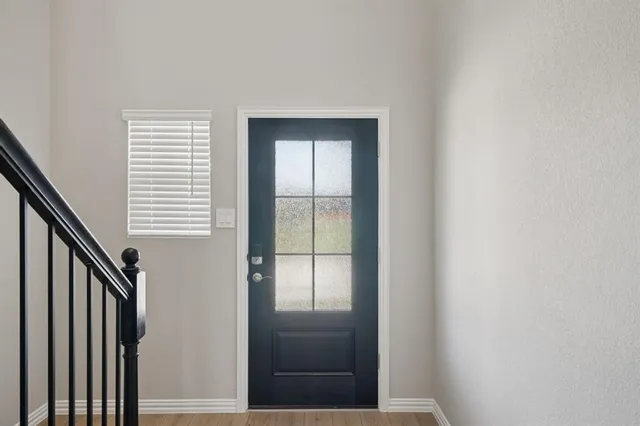 a view of staircase with wooden floor and white walls