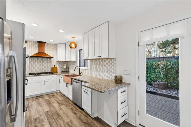 a kitchen with a refrigerator a stove a sink dishwasher and wooden cabinets with wooden floor