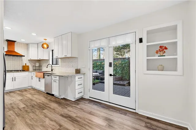 a kitchen with white cabinets and window