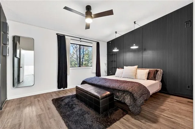 a spacious bedroom with a bed and wooden floor