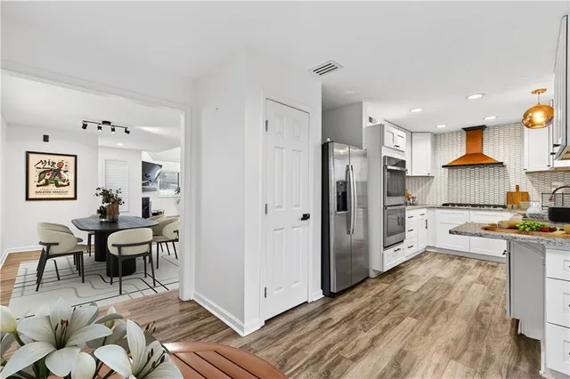 a kitchen with stainless steel appliances a refrigerator and a stove top oven