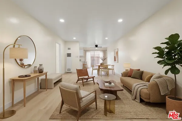 a living room with furniture a mirror and a chandelier