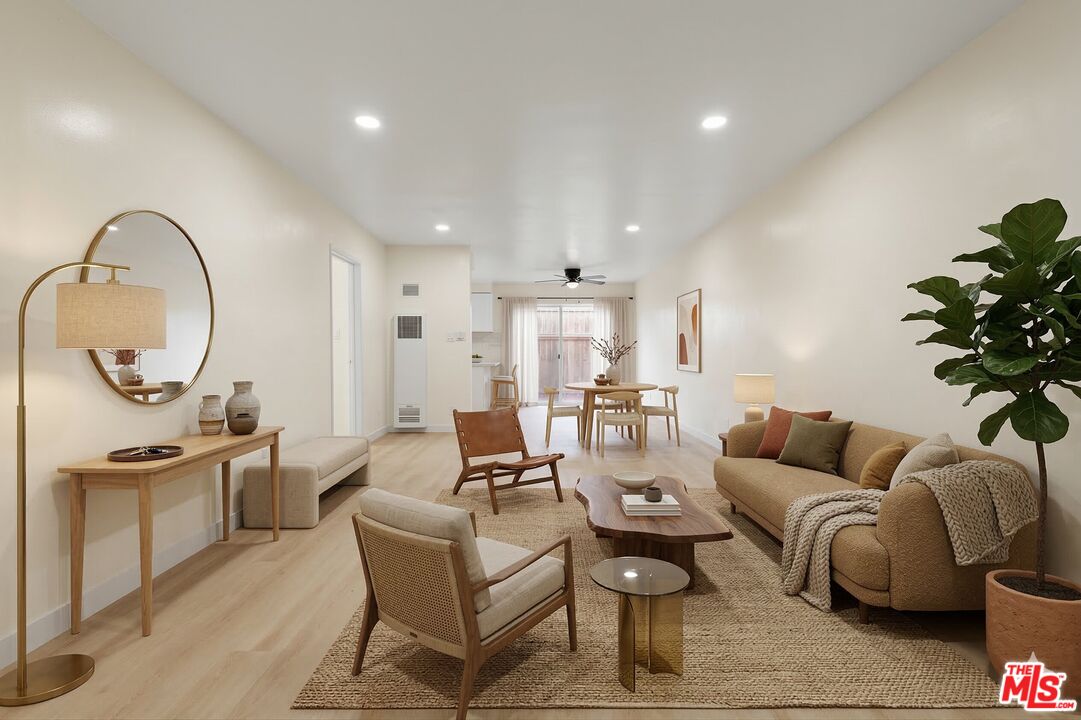 7825 West Manchester Avenue, Unit 10 Playa del Rey, CA 90293 - Photo 3 of 15 a living room with furniture a mirror and a chandelier