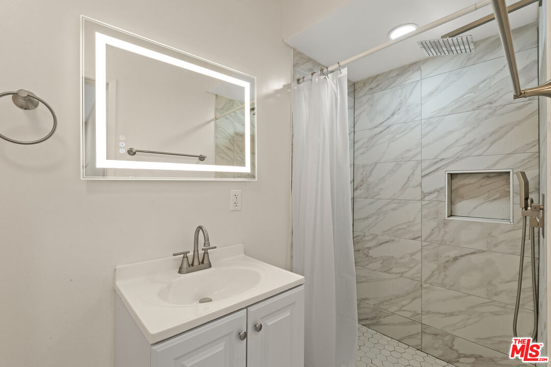 7825 West Manchester Avenue, Unit 10 Playa del Rey, CA 90293 - Photo 9 of 15 a bathroom with a sink a toilet and a mirror