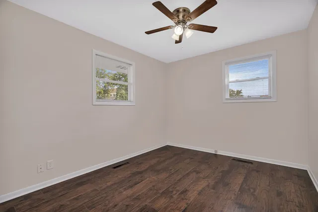 a view of empty room with wooden floor