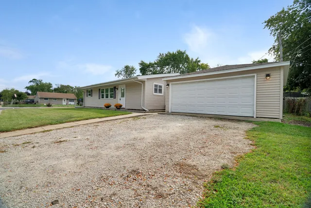a front view of house with yard and trees all around