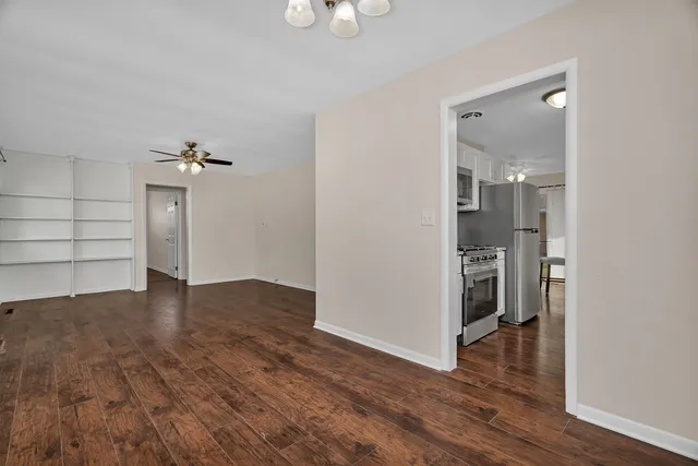 a view of empty room with wooden floor and window