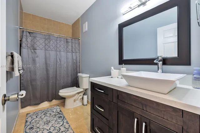 a bathroom with a double vanity sink toilet and a mirror