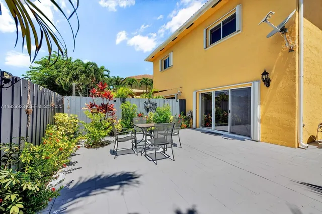 a view of a patio with plants and table and chairs