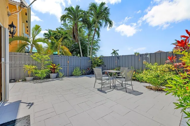 a view of a patio with a table and chairs and potted plants