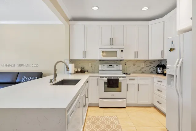 a kitchen with stainless steel appliances granite countertop a sink and white cabinets