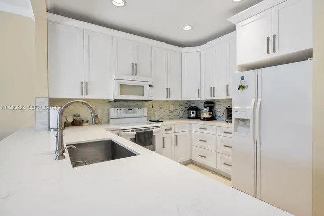 a kitchen with white cabinets and stainless steel appliances