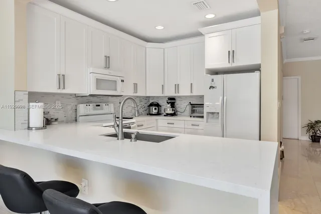 a kitchen with stainless steel appliances a sink a refrigerator and cabinets