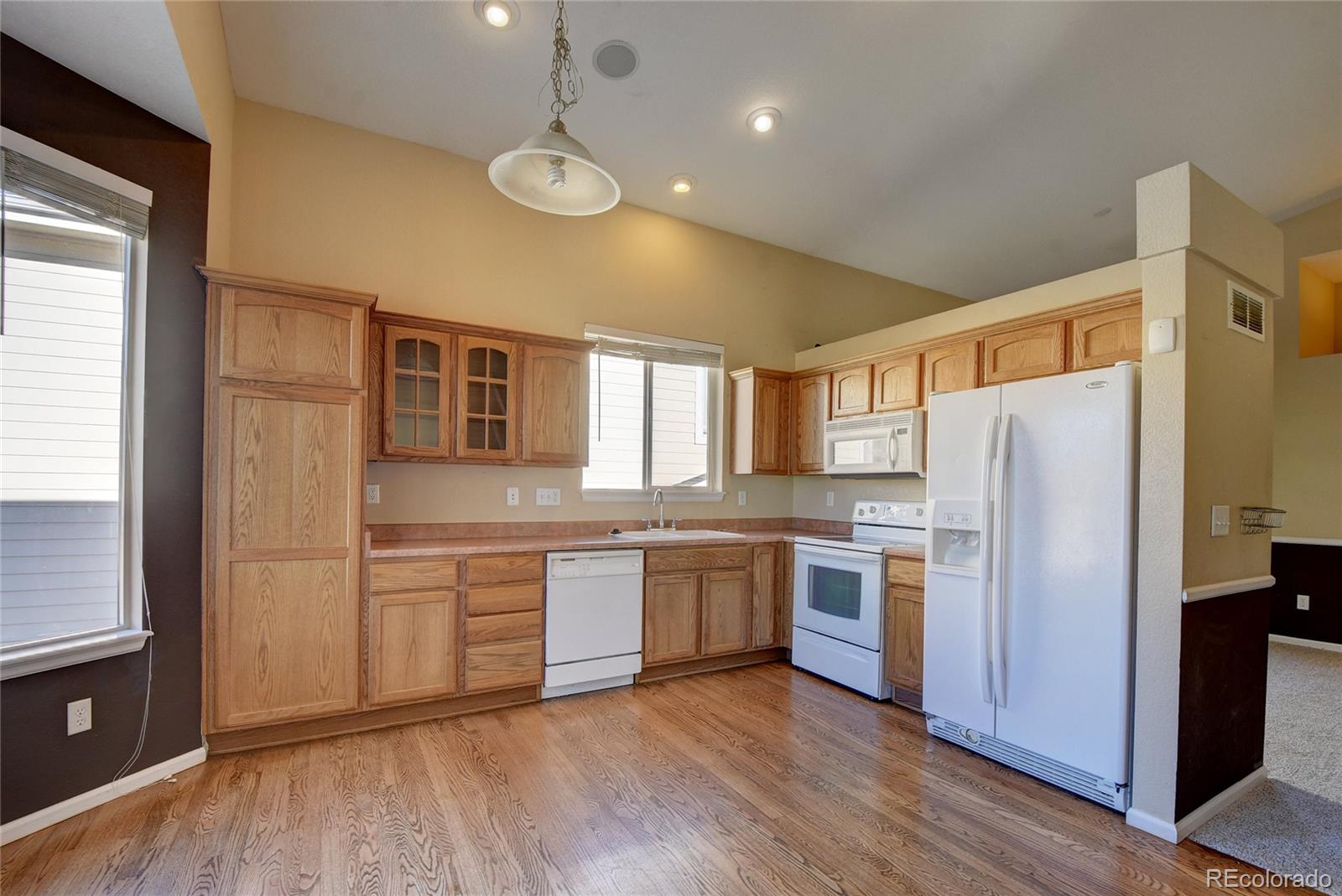 10845 Towerbridge Road Highlands Ranch, CO 80130 - Photo 15 of 35 a kitchen with stainless steel appliances granite countertop cabinets and wooden floor