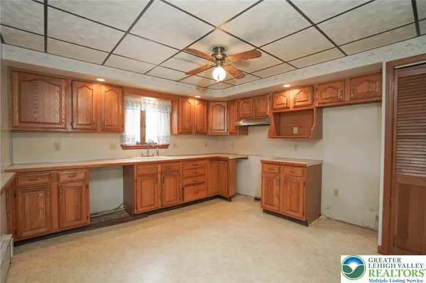a large kitchen with stainless steel appliances wooden cabinets a sink and a dishwasher