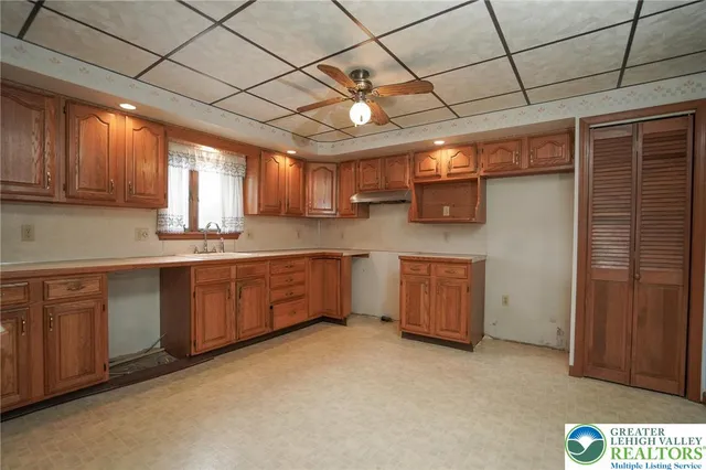 a kitchen with cabinets a window and appliances
