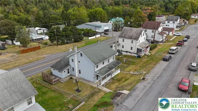 an aerial view of a house with garden space and street view