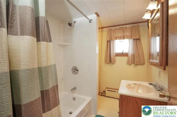 a bathroom with a tub shower vanity and a sink