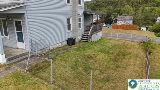 a view of a patio with table and chairs near a yard
