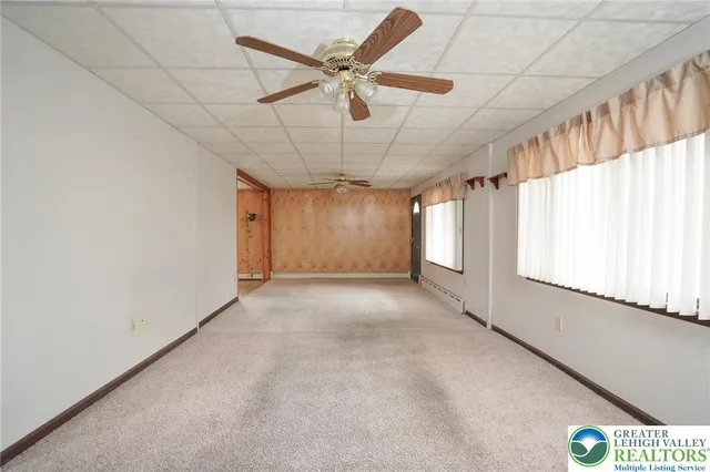 a view of a livingroom with a ceiling fan and window