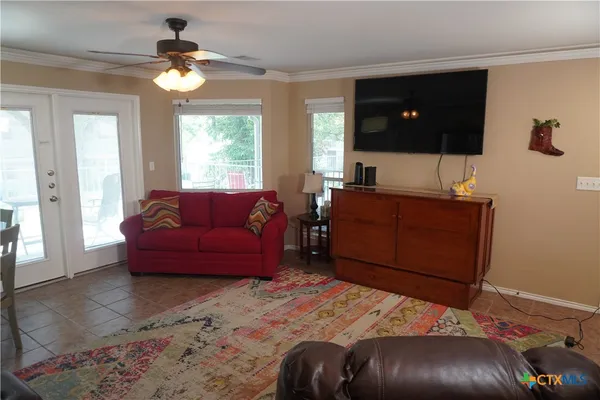 a living room with a bed furniture and flat screen tv