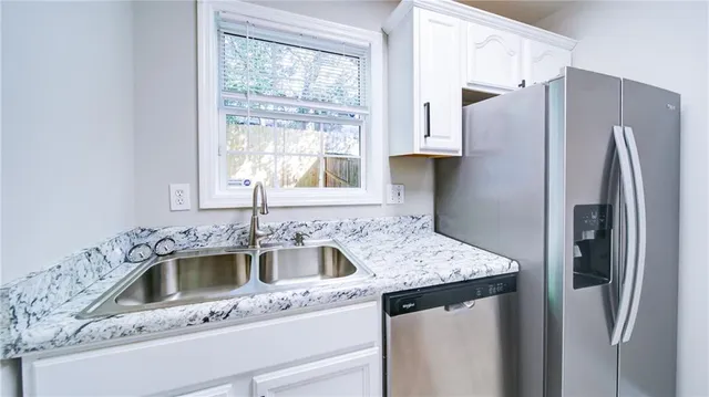a kitchen with a sink a refrigerator and window