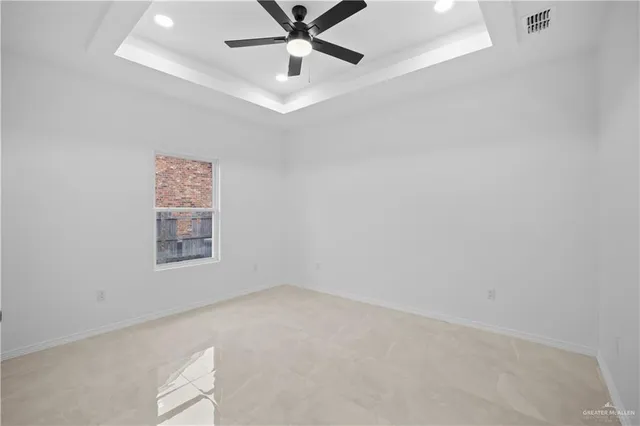 an empty room with a window and ceiling fan