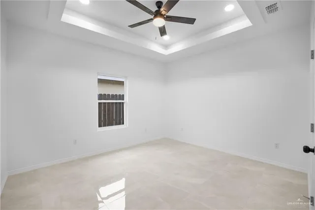 an empty room with a window and ceiling fan