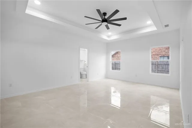 an empty room with windows and fan