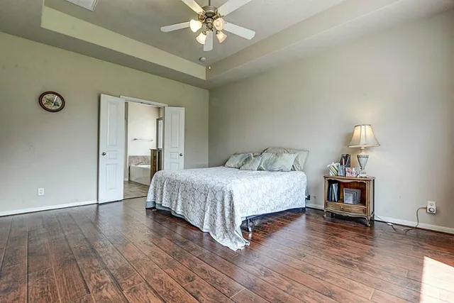 a bedroom with a bed and wooden floor