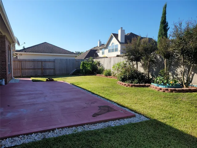 a view of a house with a yard and a large tree