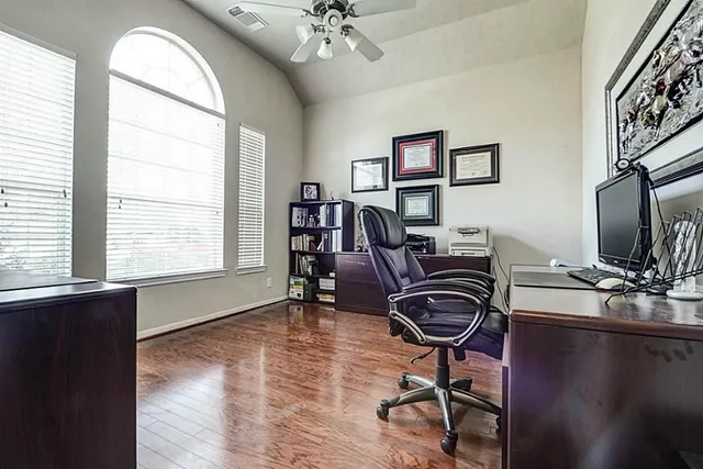 a view of a workspace with furniture and a window