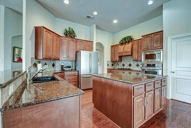 a kitchen with stainless steel appliances granite countertop a sink stove and refrigerator