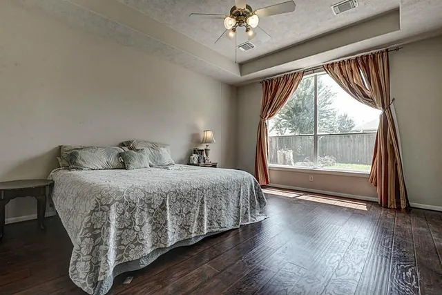 a spacious bedroom with a bed and a large window