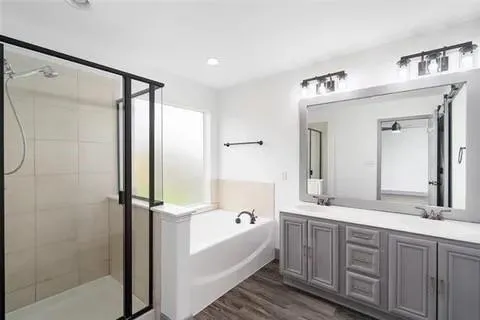 a bathroom with a double vanity sink toilet mirror and bathtub