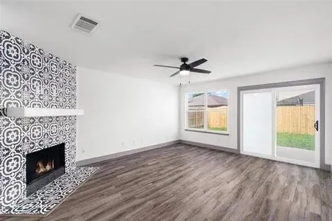 a view of empty room with wooden floor and fireplace