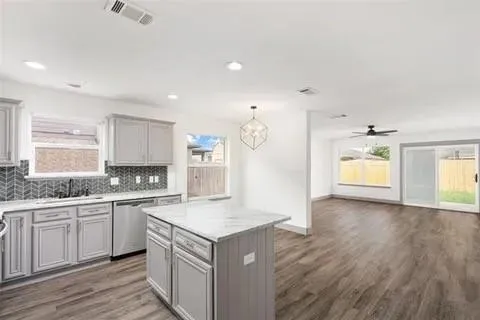 a kitchen with a sink cabinets and wooden floor
