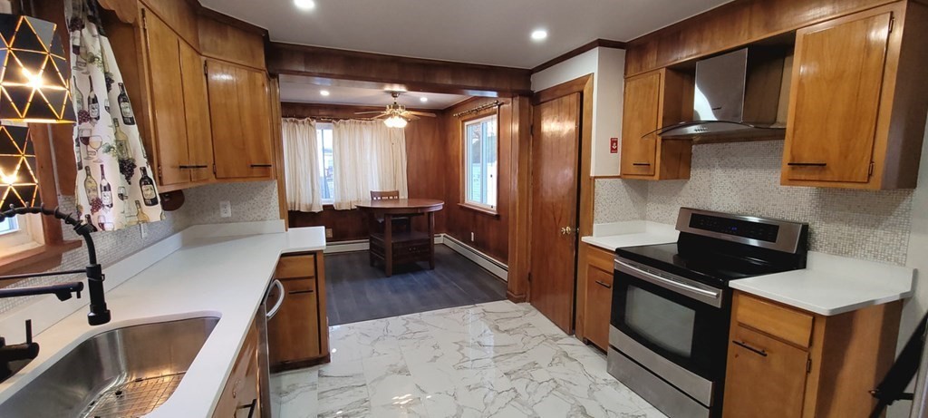 91 Rimmon Avenue Chicopee, MA 01013 - Photo 6 of 18 a kitchen with stainless steel appliances granite countertop a refrigerator a stove and a sink with wooden floor