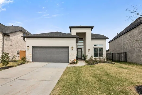 a front view of a house with yard and garage