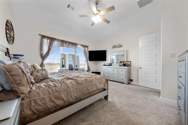 a bedroom with a bed a couch and a flat screen tv