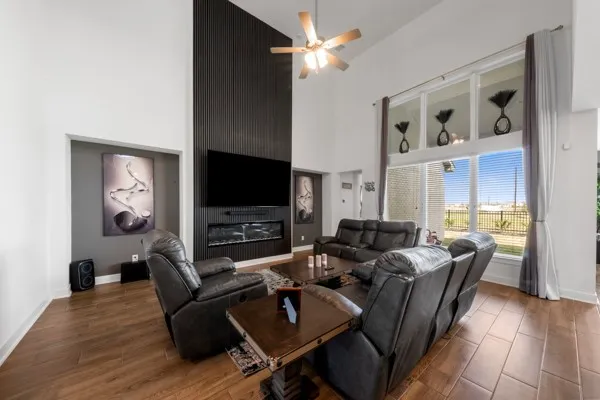 a living room with furniture a flat screen tv and kitchen view