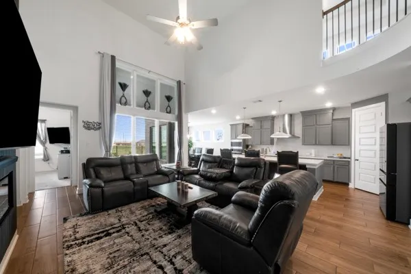 a living room with furniture a flat screen tv and kitchen view