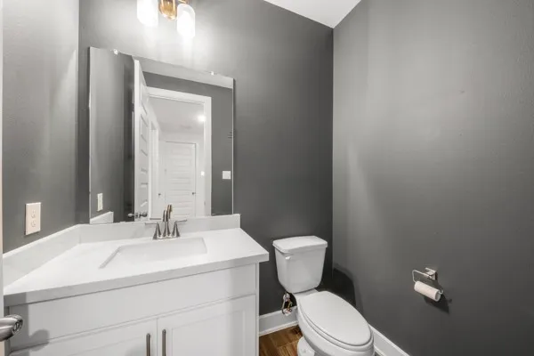 a bathroom with a sink mirror vanity and toilet
