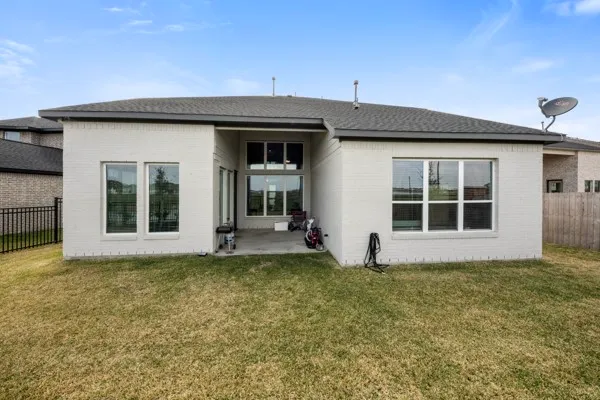 a view of a house with large windows and plants