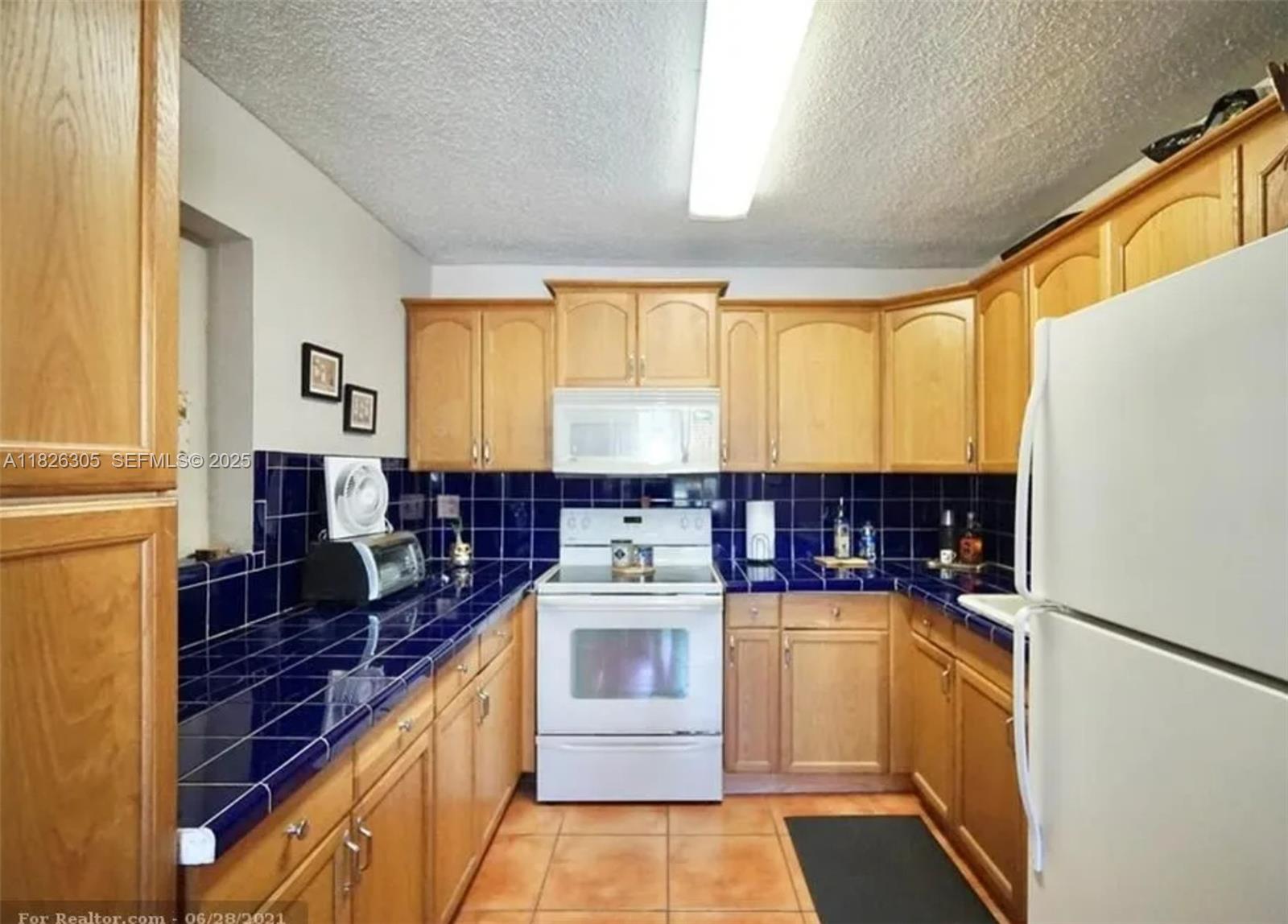 6103 Monroe Street Hollywood, FL 33023 - Photo 7 of 9 a kitchen with a stove top oven and refrigerator