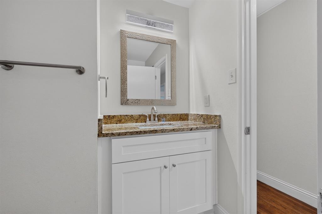 405 Easton Road Dallas, TX 75218 - Photo 19 of 36 White vanity with shaker-style cabinetry, a granite countertop, and an undermount sink