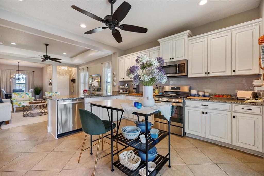 208 Brienza Loop Nokomis, FL 34275 - Photo 9 of 45 a kitchen with a dining table chairs and white cabinets